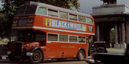Colour camera picture of a red London bus with the words 'Black and white' advertised on the side.