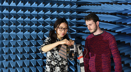 Researchers testing equipment in anechoic chamber
