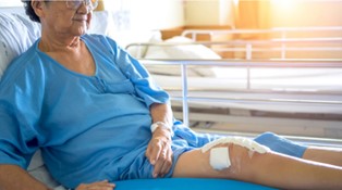 patient laying on a hospital bed after a knee replacement