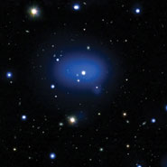 X-rays from Chandra are displayed as the diffuse blue region, while the individual galaxies in the cluster are seen in white, embedded in the X-ray emission